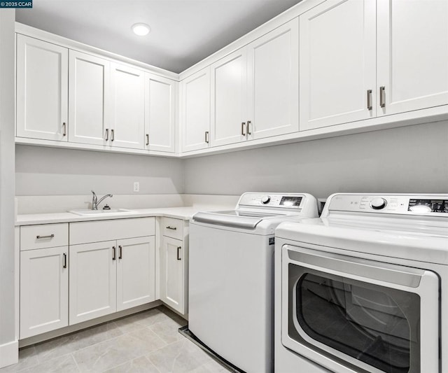 laundry area with light tile patterned floors, independent washer and dryer, sink, and cabinets