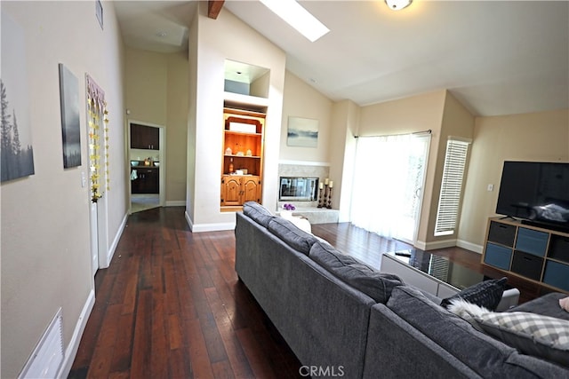 living room with dark hardwood / wood-style flooring and vaulted ceiling with skylight