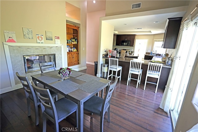 dining area featuring dark hardwood / wood-style flooring and a fireplace