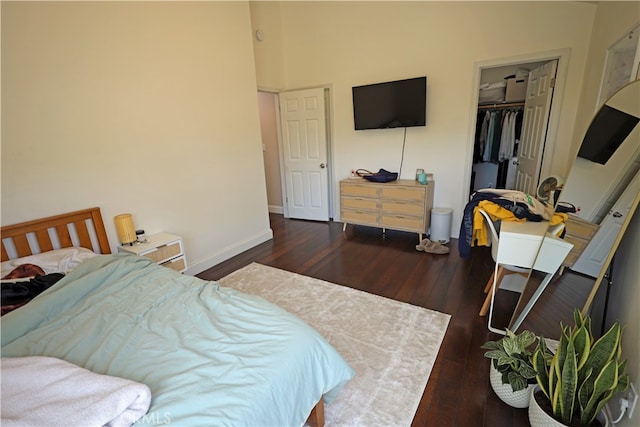 bedroom with dark hardwood / wood-style flooring, a closet, and a walk in closet