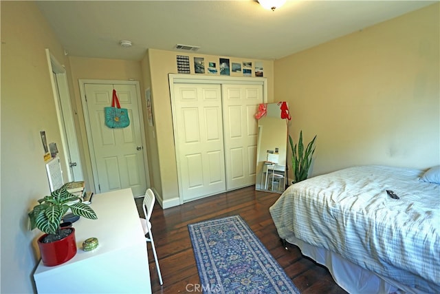 bedroom with dark hardwood / wood-style flooring and a closet