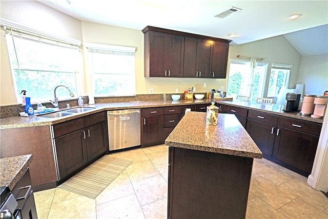 kitchen with light tile patterned floors, a kitchen island, stainless steel dishwasher, light stone countertops, and sink