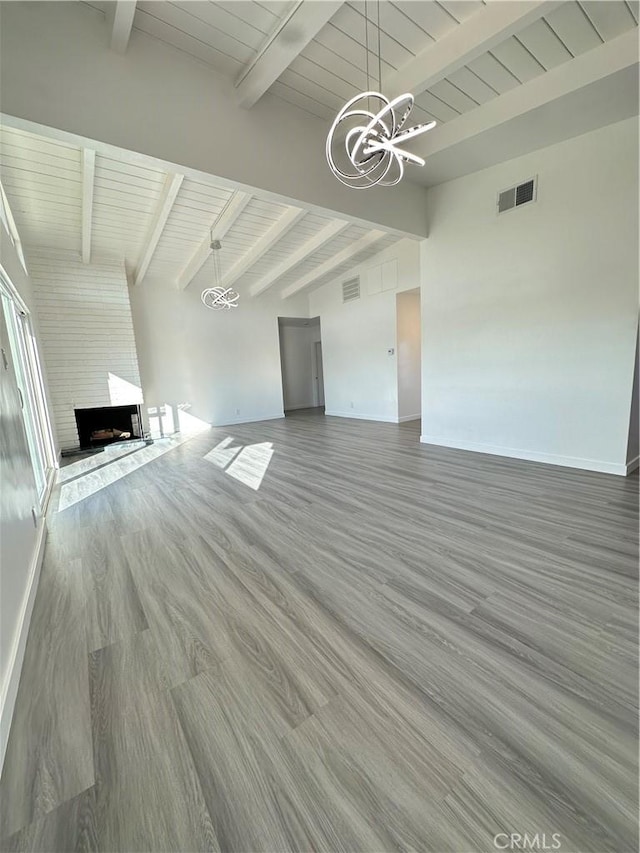 unfurnished living room featuring hardwood / wood-style floors, wooden ceiling, a fireplace, and a chandelier