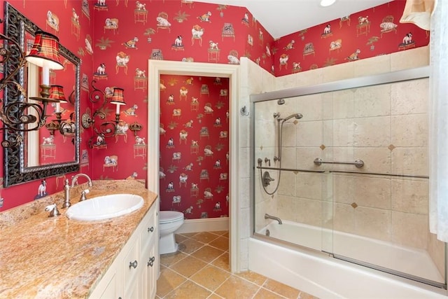 full bathroom featuring tile patterned flooring, vanity, enclosed tub / shower combo, and toilet