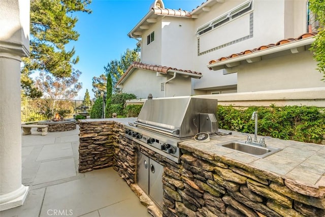 view of patio with an outdoor kitchen, sink, and grilling area