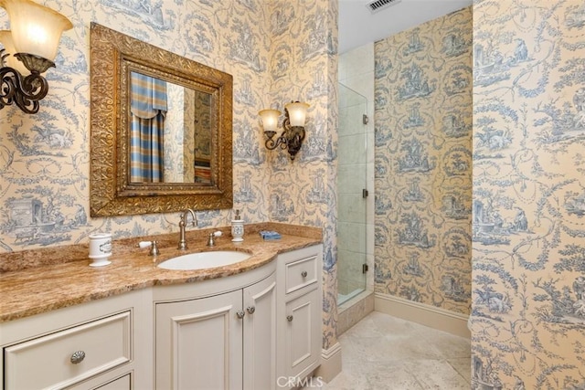 bathroom with a tile shower, tile patterned flooring, and vanity