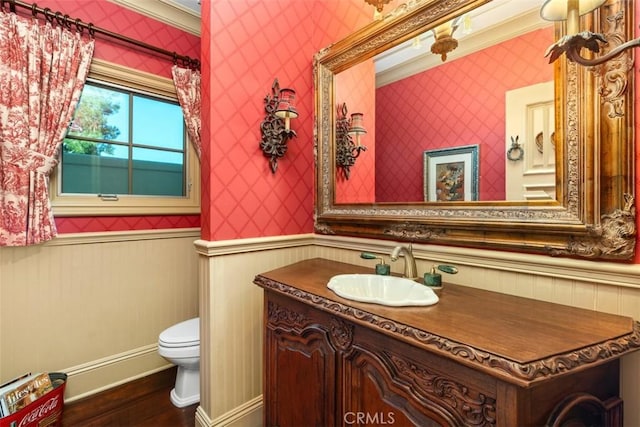 bathroom with hardwood / wood-style floors, vanity, toilet, and crown molding