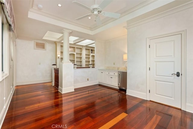 kitchen featuring ornate columns, a tray ceiling, crown molding, white cabinets, and dark hardwood / wood-style floors