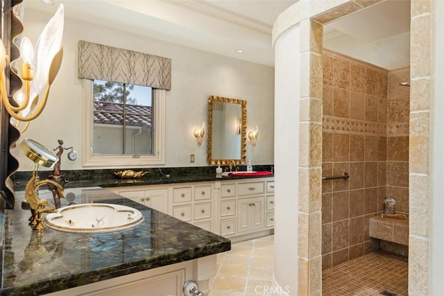 bathroom with tiled shower, vanity, and tile patterned floors