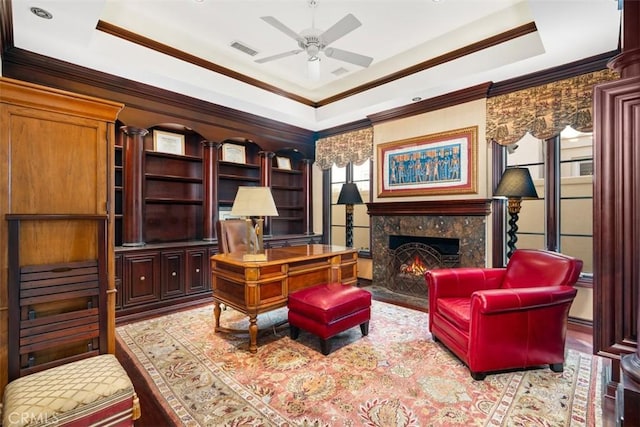 office space featuring a tray ceiling, a premium fireplace, and ornamental molding