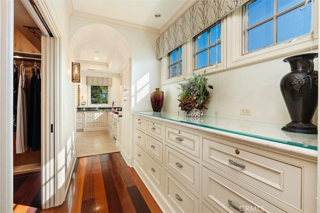 hallway with dark hardwood / wood-style flooring and crown molding