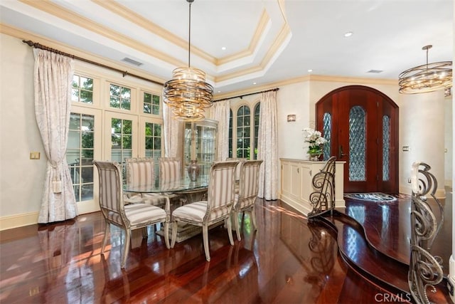 dining space featuring french doors, ornamental molding, a raised ceiling, a notable chandelier, and dark hardwood / wood-style floors