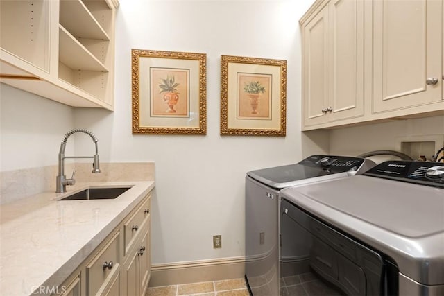 laundry area with tile patterned flooring, cabinets, independent washer and dryer, and sink