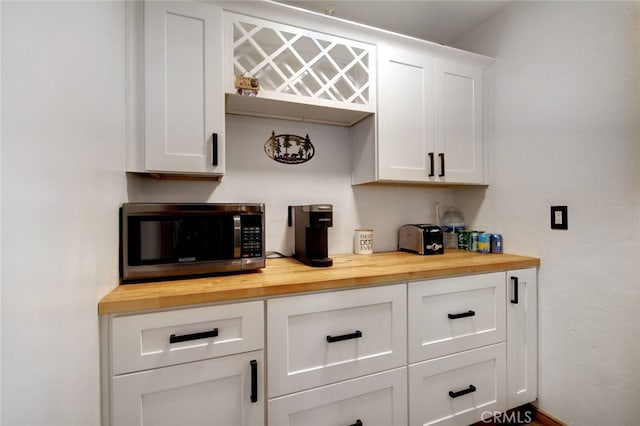 kitchen featuring white cabinetry and butcher block counters