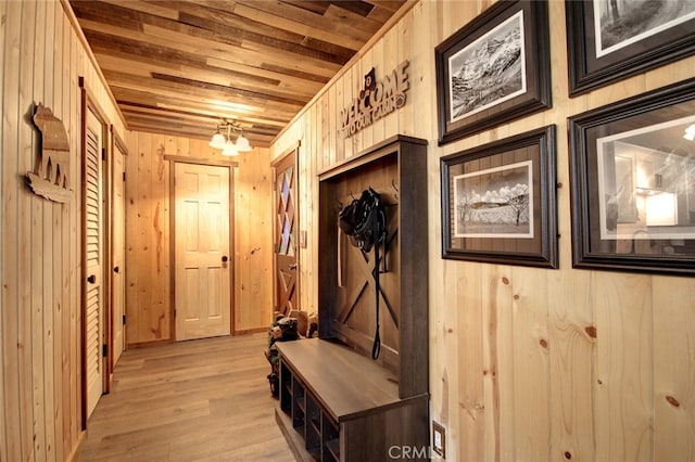 mudroom with wooden walls, wooden ceiling, and light hardwood / wood-style flooring