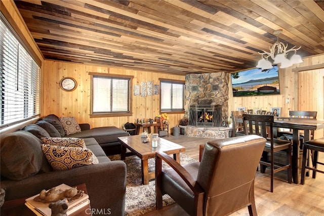 living room with wooden ceiling, wooden walls, hardwood / wood-style flooring, and a stone fireplace