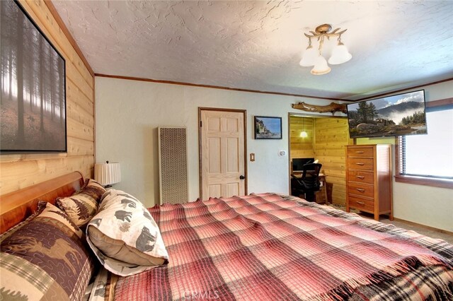 bedroom with crown molding, a textured ceiling, wood walls, and radiator heating unit