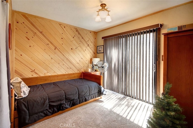 bedroom with carpet floors and wood walls