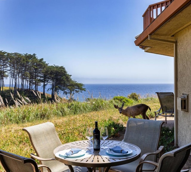 view of patio featuring a water view and a balcony