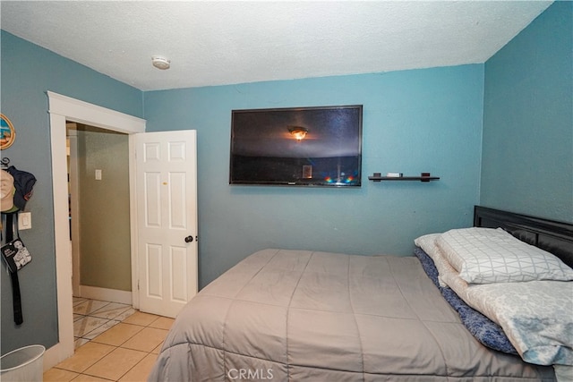 bedroom with a textured ceiling and light tile patterned floors