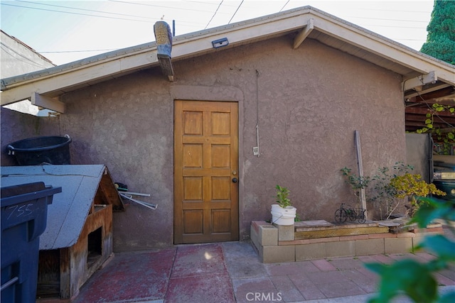 view of exterior entry with a patio area