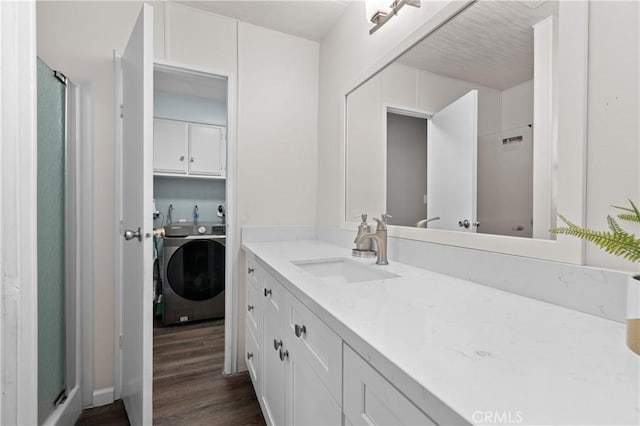 bathroom with walk in shower, washer / clothes dryer, vanity, and hardwood / wood-style flooring