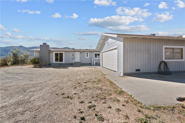 back of property featuring a garage and a mountain view