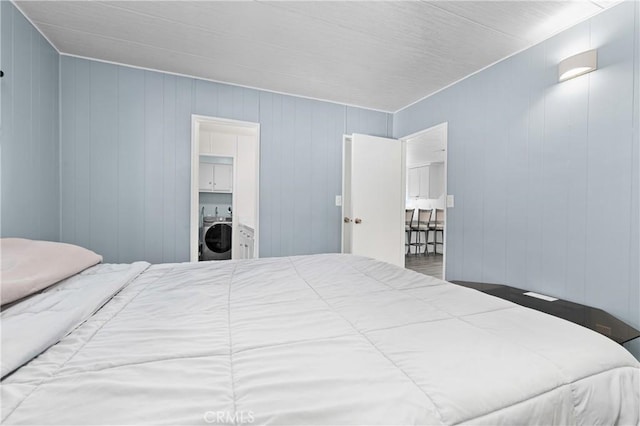 bedroom with washer / dryer and wooden walls