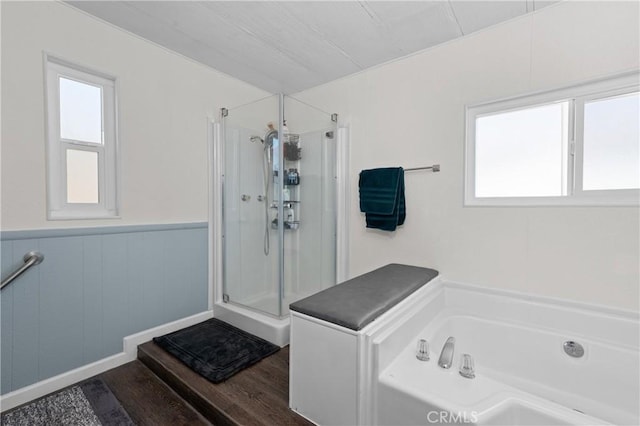 bathroom with independent shower and bath and wood-type flooring