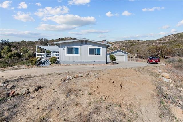 view of front of house with a carport, a mountain view, an outdoor structure, and a garage