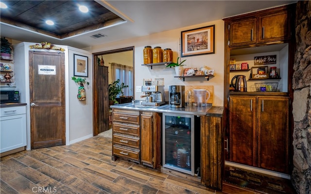 kitchen with beverage cooler, a tray ceiling, and dark hardwood / wood-style floors