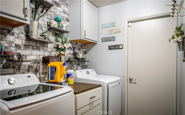 laundry area with washing machine and clothes dryer and cabinets