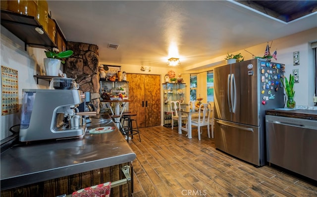 kitchen with stainless steel appliances and hardwood / wood-style flooring