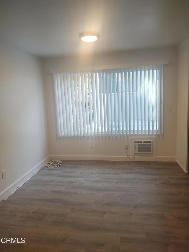 empty room with dark hardwood / wood-style floors and a wealth of natural light