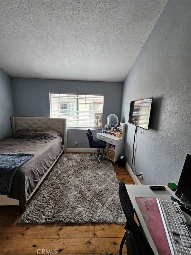 bedroom featuring a textured ceiling and hardwood / wood-style flooring