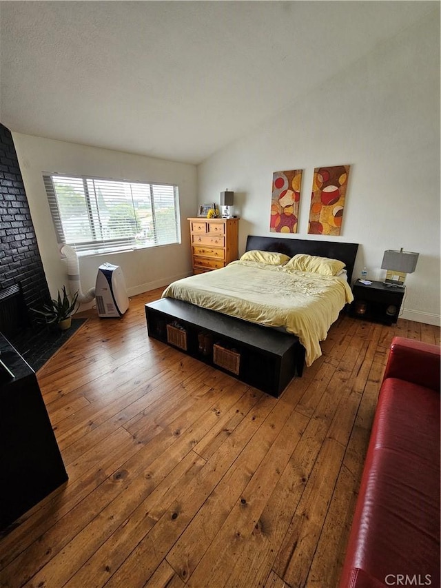 bedroom featuring hardwood / wood-style flooring and vaulted ceiling