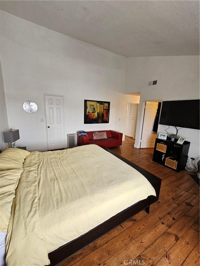 bedroom with dark hardwood / wood-style flooring and high vaulted ceiling