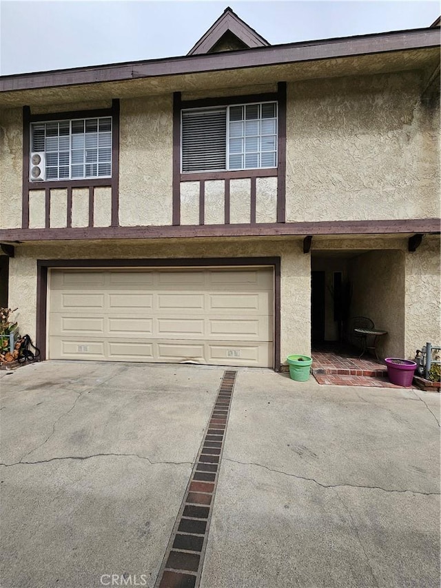 view of property featuring stucco siding, a garage, and concrete driveway