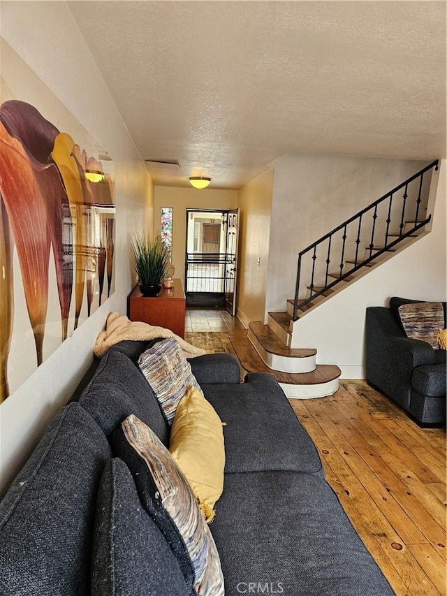 living room with light wood-type flooring and a textured ceiling