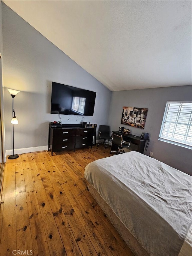 bedroom featuring light wood-type flooring and lofted ceiling