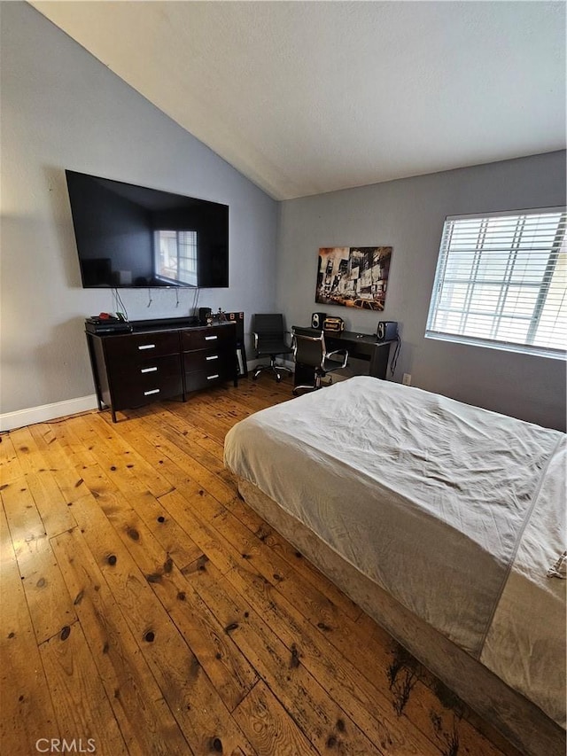 bedroom with light hardwood / wood-style flooring and lofted ceiling