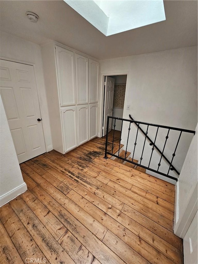 interior space with light wood-type flooring and a skylight