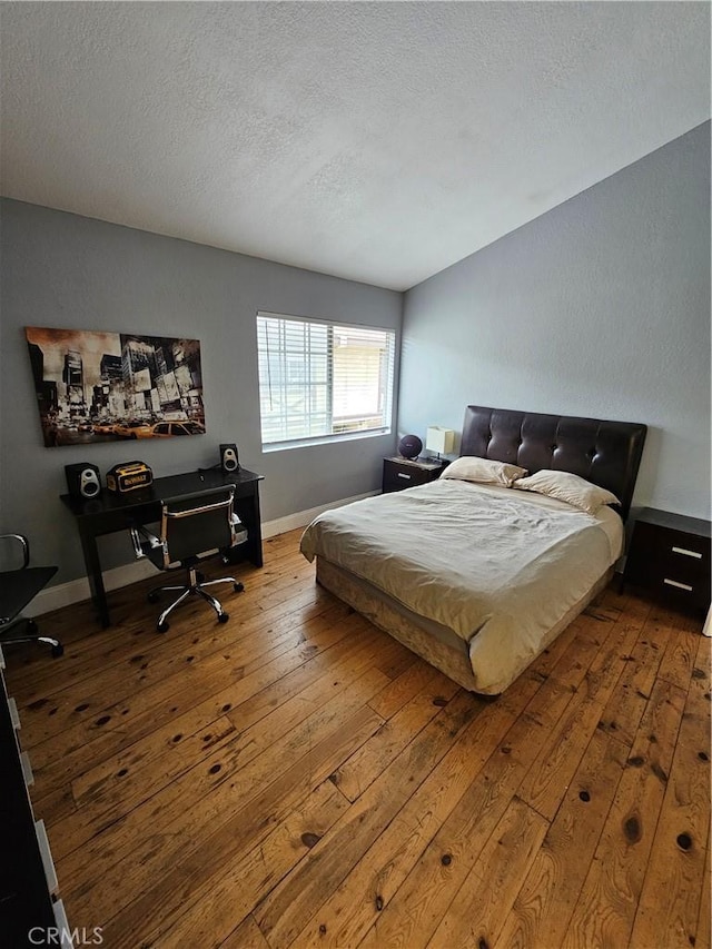 bedroom featuring a textured ceiling and hardwood / wood-style flooring