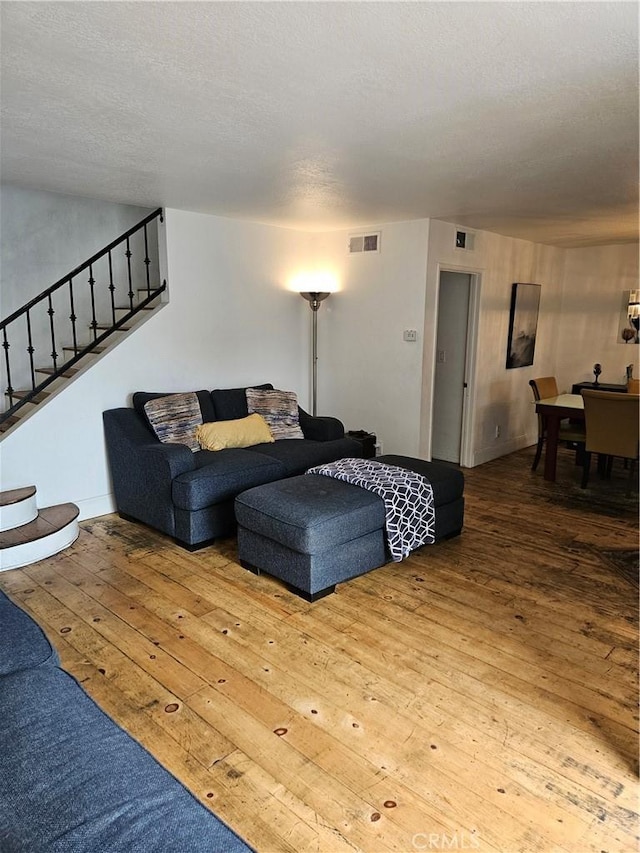 living room with wood-type flooring and a textured ceiling