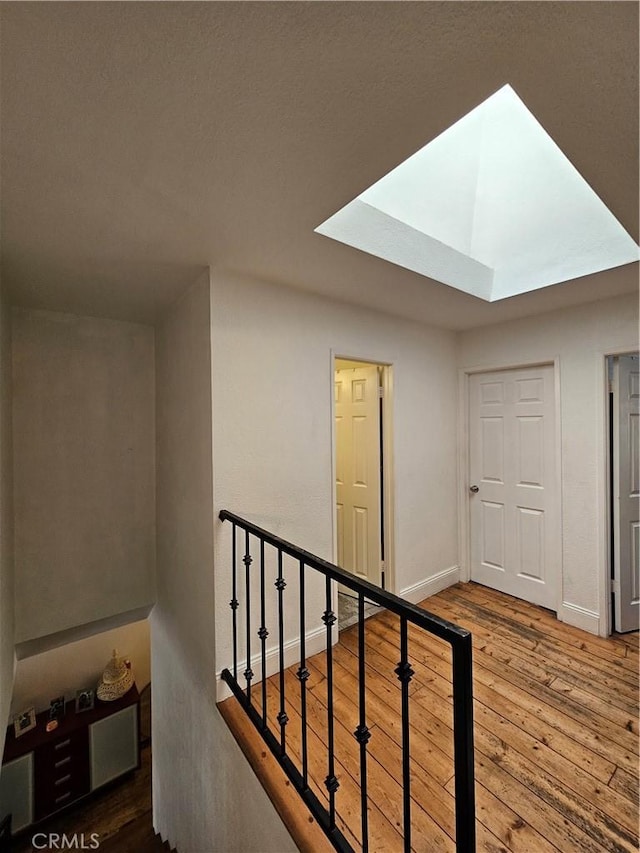 staircase featuring a skylight and hardwood / wood-style flooring