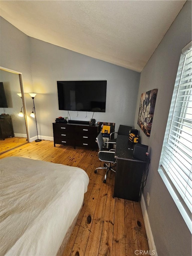 bedroom with hardwood / wood-style floors and lofted ceiling