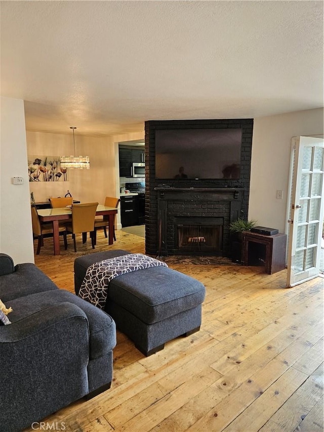 living room with light hardwood / wood-style floors and a brick fireplace