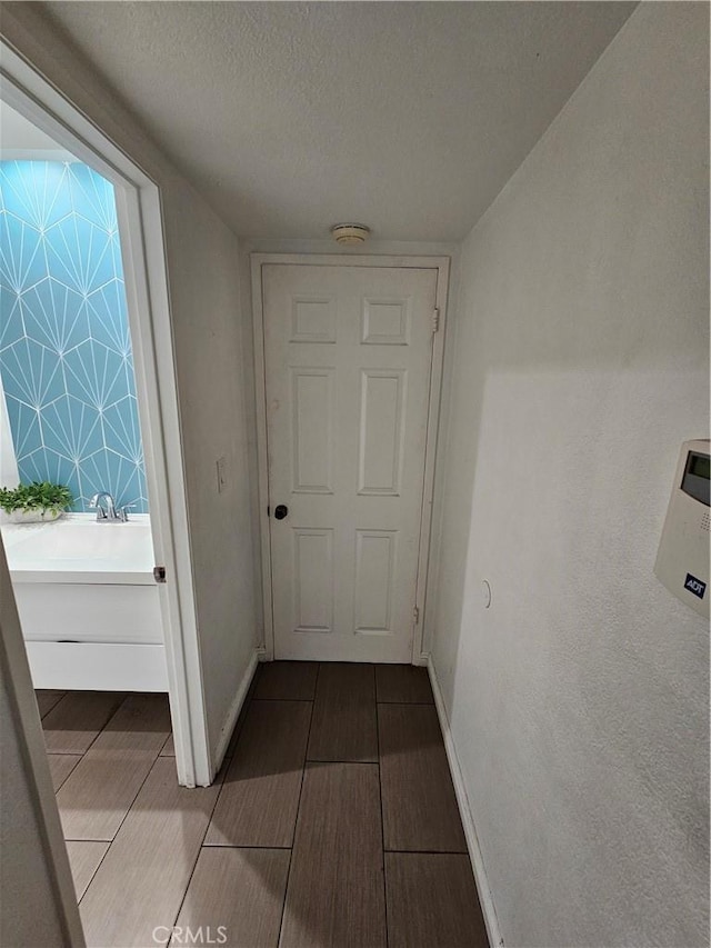 hallway with a textured ceiling