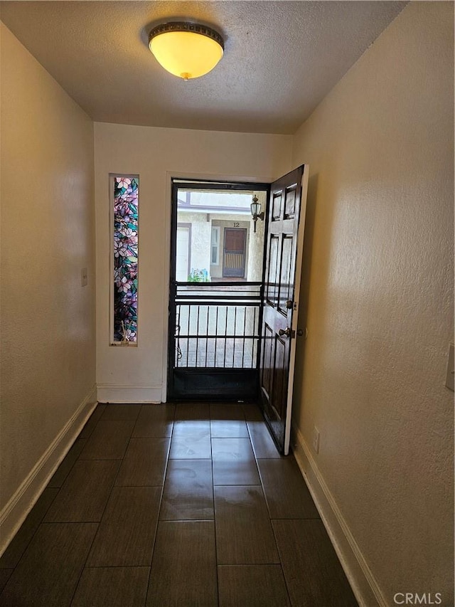 doorway to outside featuring a textured ceiling