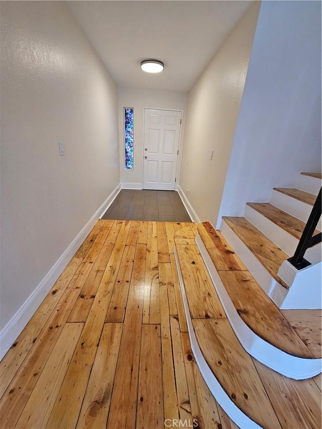 interior space with baseboards, stairs, and hardwood / wood-style flooring